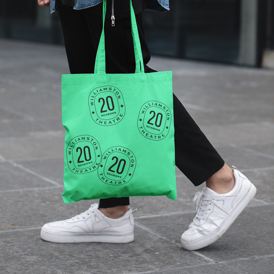 A bright green tote featuring a repeated badge icon celebrating 20 Seasons of theatre at Williamston Theatre.