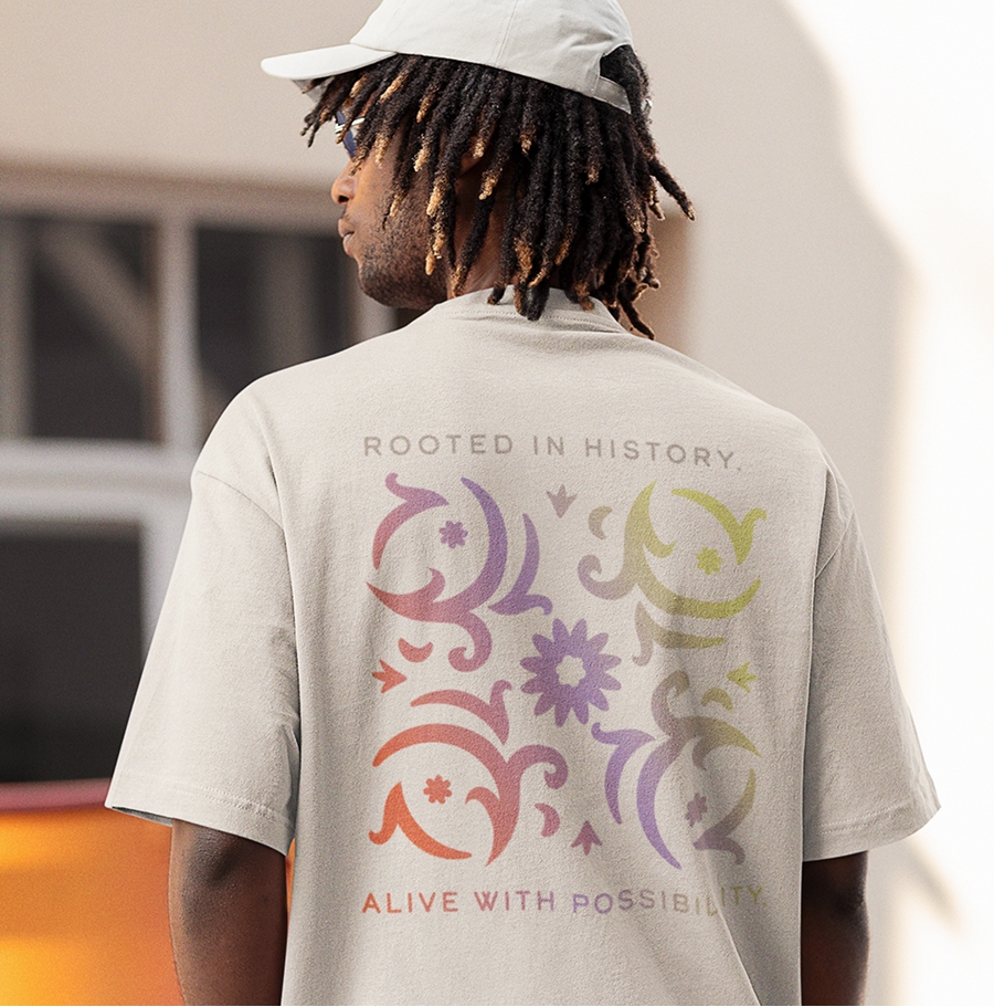Colorful t-shirt with a branded floral decoration and the words: "Rooted in history. Alive with possibility."