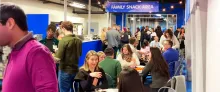 Crowd of people mingling at a family snack area